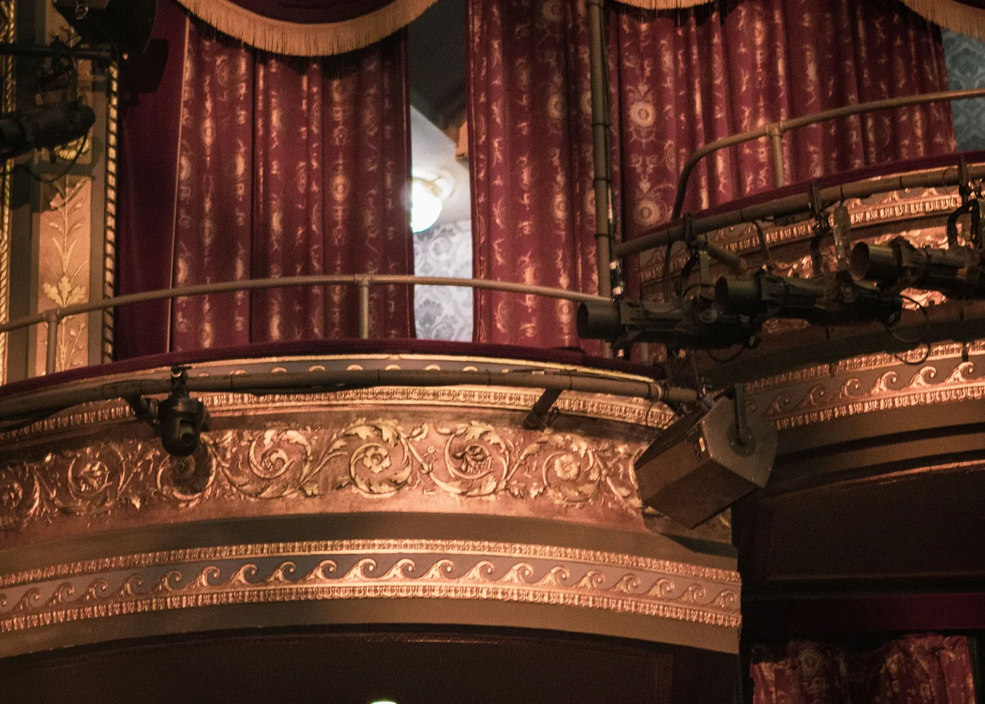 Tiered balcony boxes in red and gold inside a period theatre